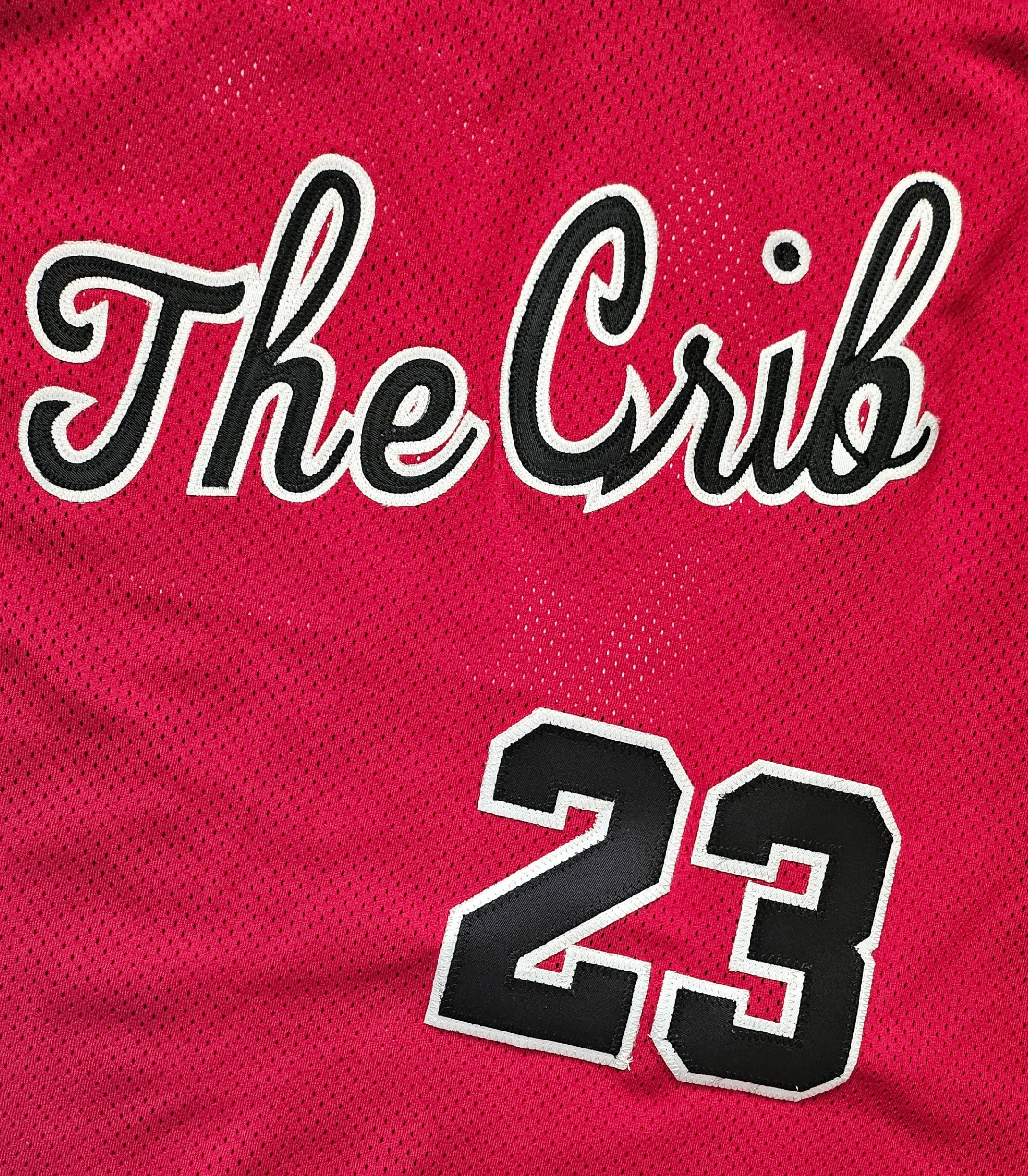 Red sports jersey with 'The Crib' and number '23', featuring a patch on the sleeve.
