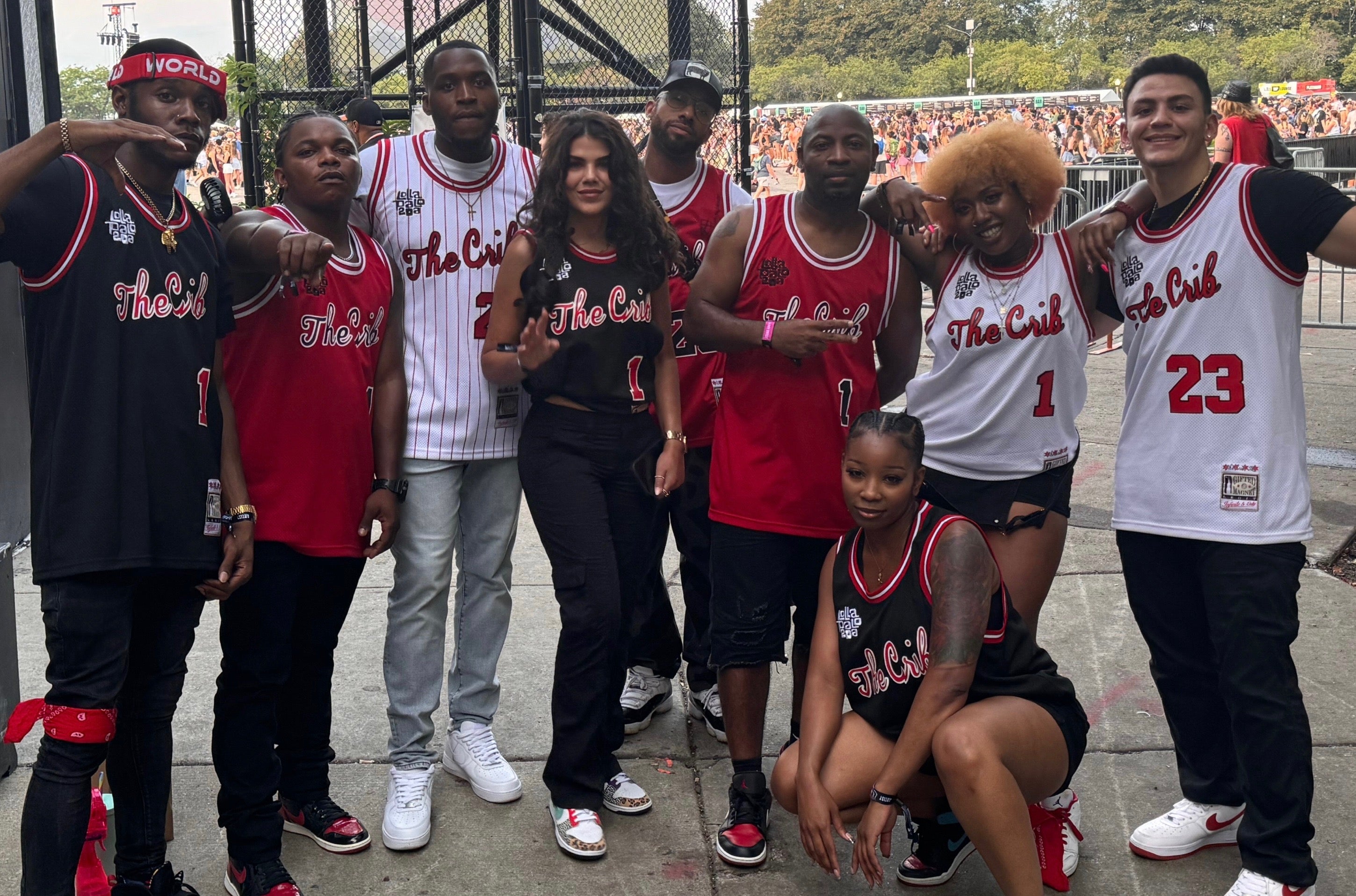 Group of people wearing 'The Crib' basketball jerseys posing outdoors.