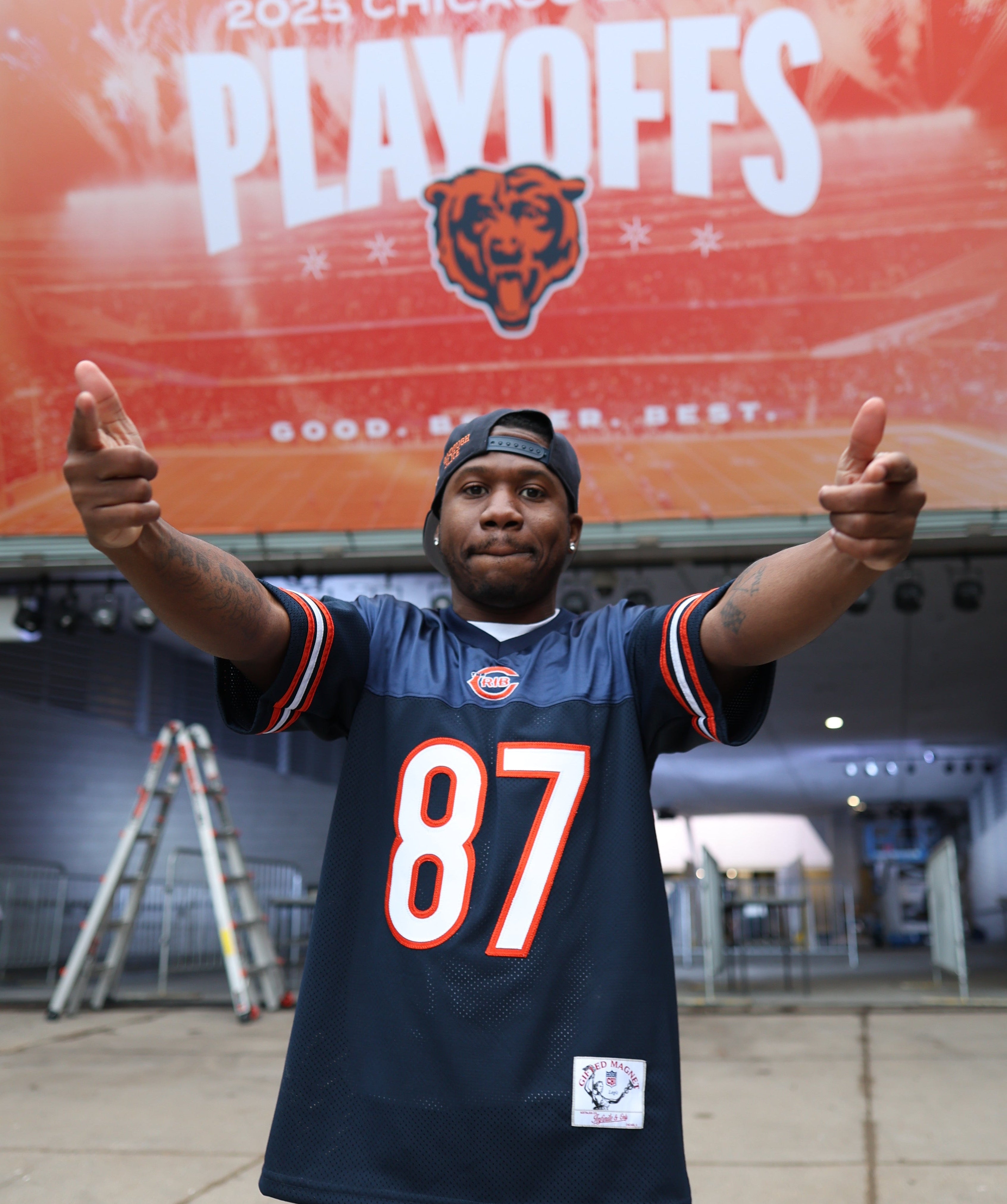 Person wearing a The Crib Jersey Football jersey with a large screen displaying 'Bears' in the background